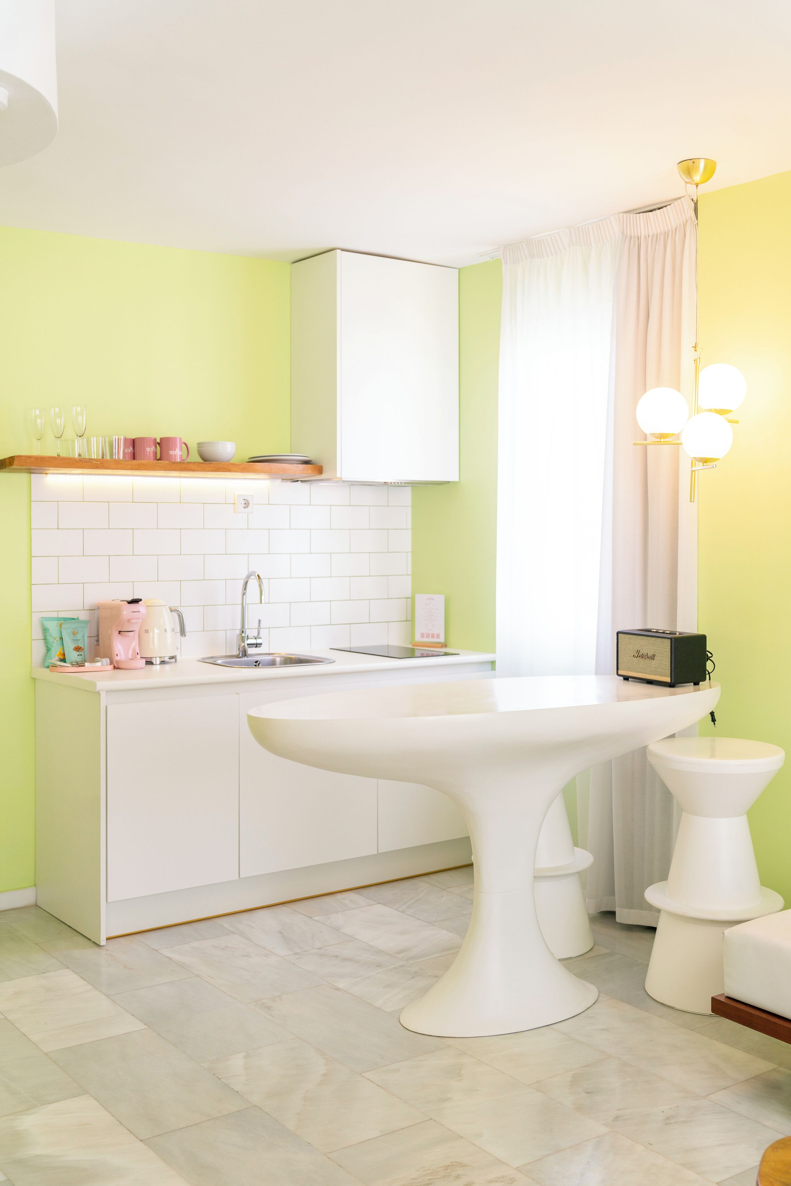 Una cocina moderna con encimera blanca, pileta integrada y mesa blanca.
