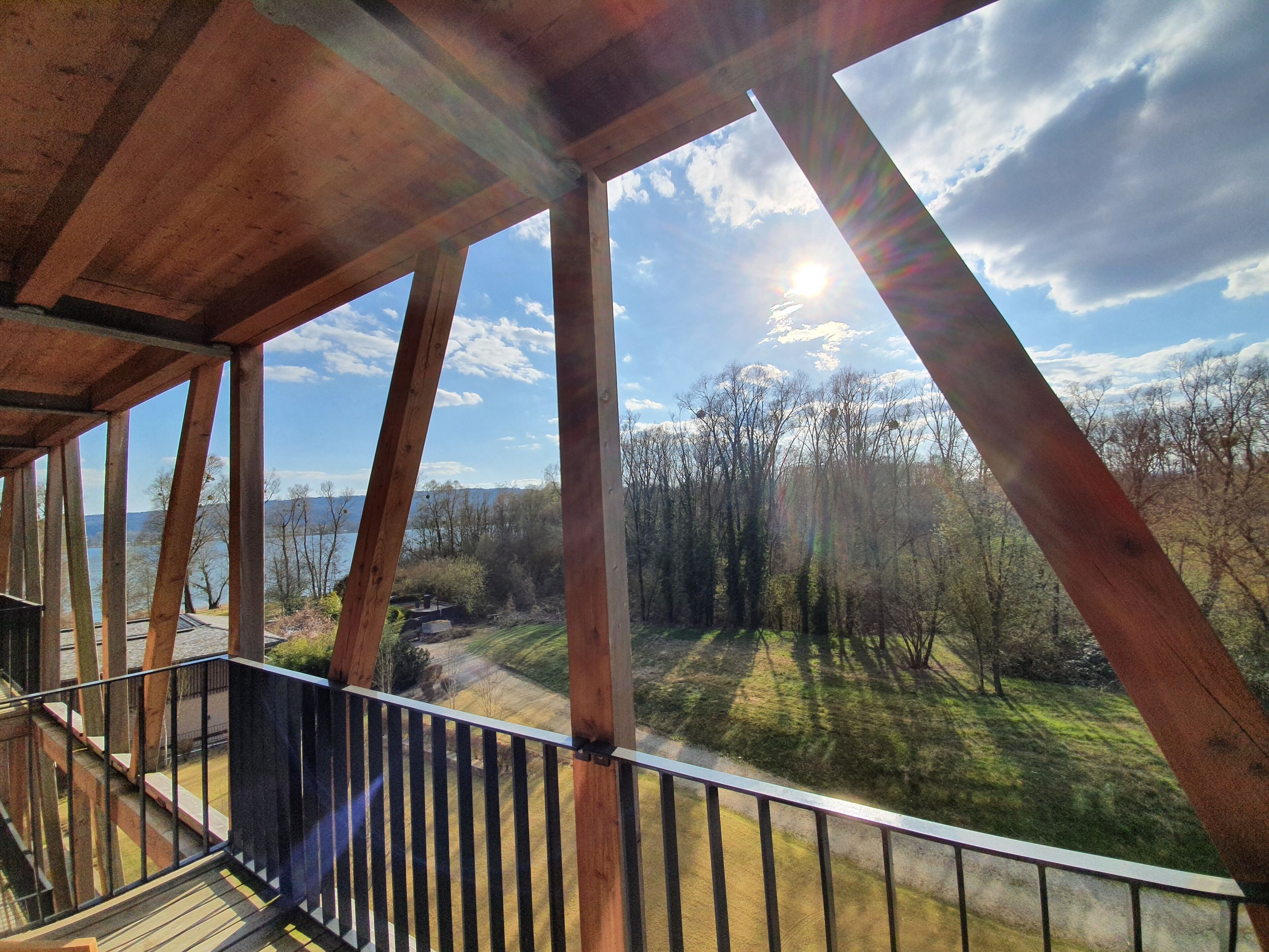 Un balcón de madera con vistas a un bosque y montañas.