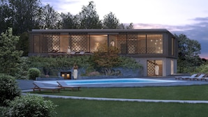 A modern building with a pool, lounge chairs, and a well-maintained garden. - Hotel Bora HotSpaResort (Radolfzell am Bodensee)