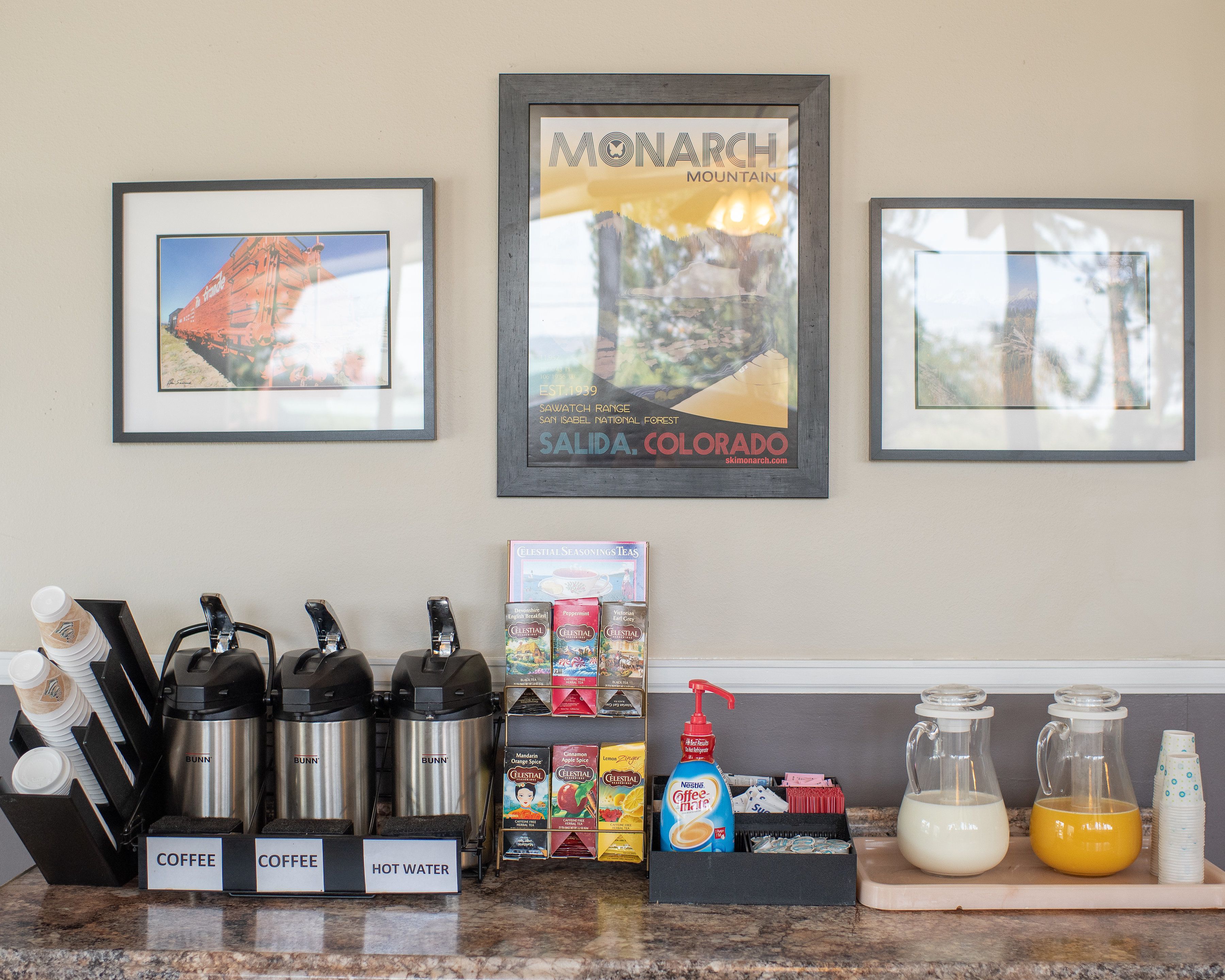 A kitchen counter with coffee makers, hot water station, and a coffee and tea display.