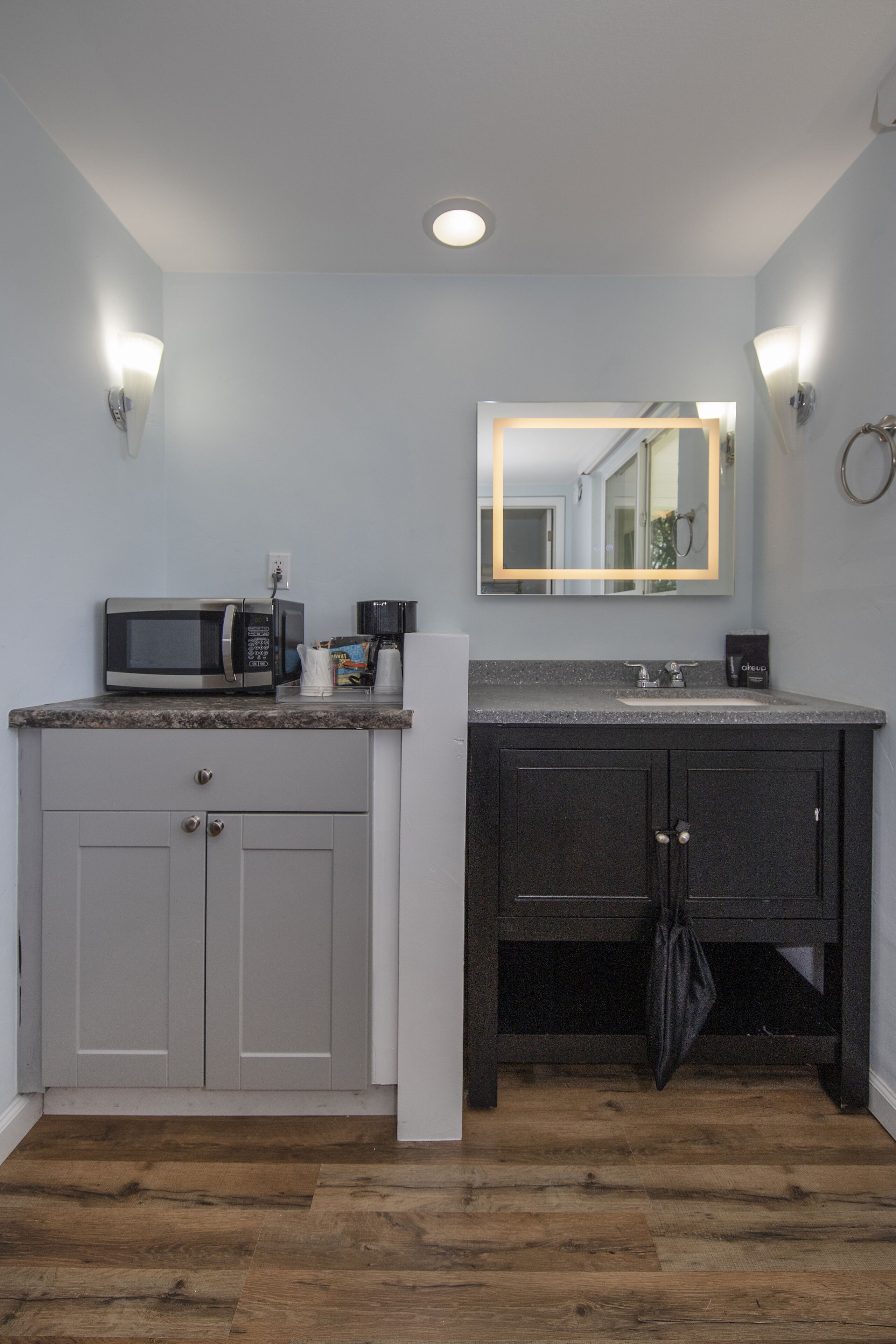 Una cocina equipada con microondas, cafetera y fregadero.