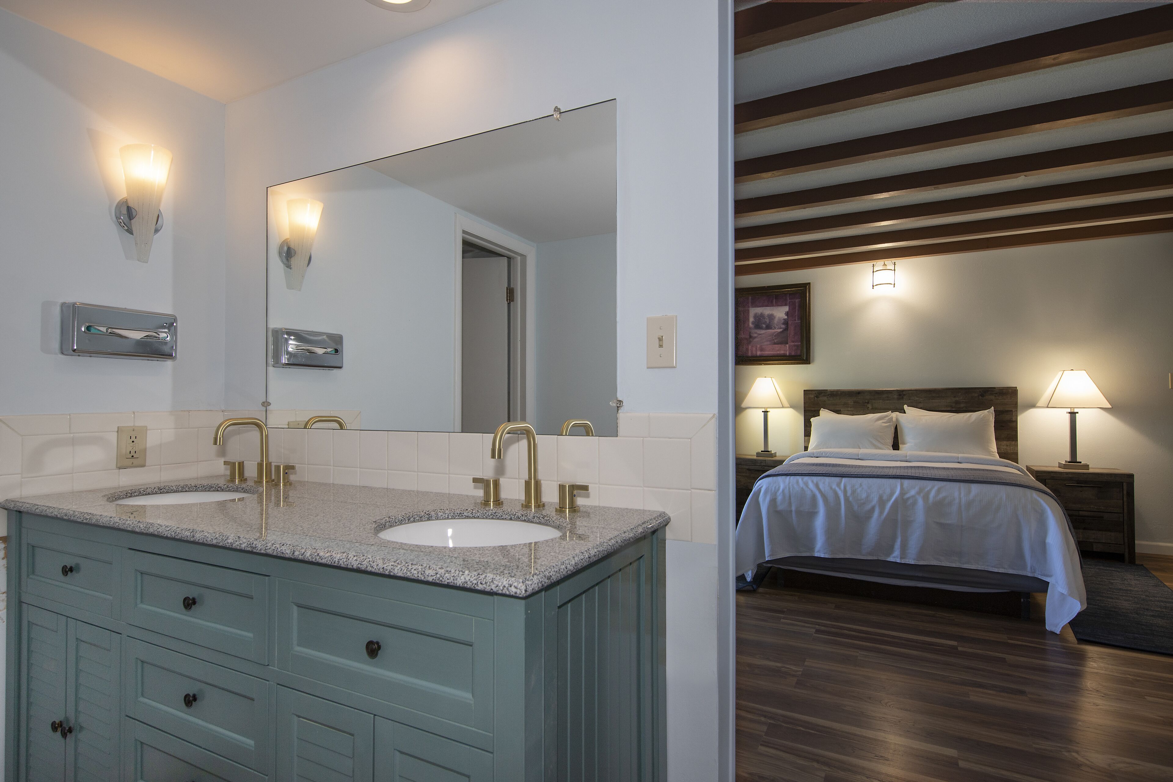 A bathroom with dual sinks, a large mirror, and a vanity with drawers.
