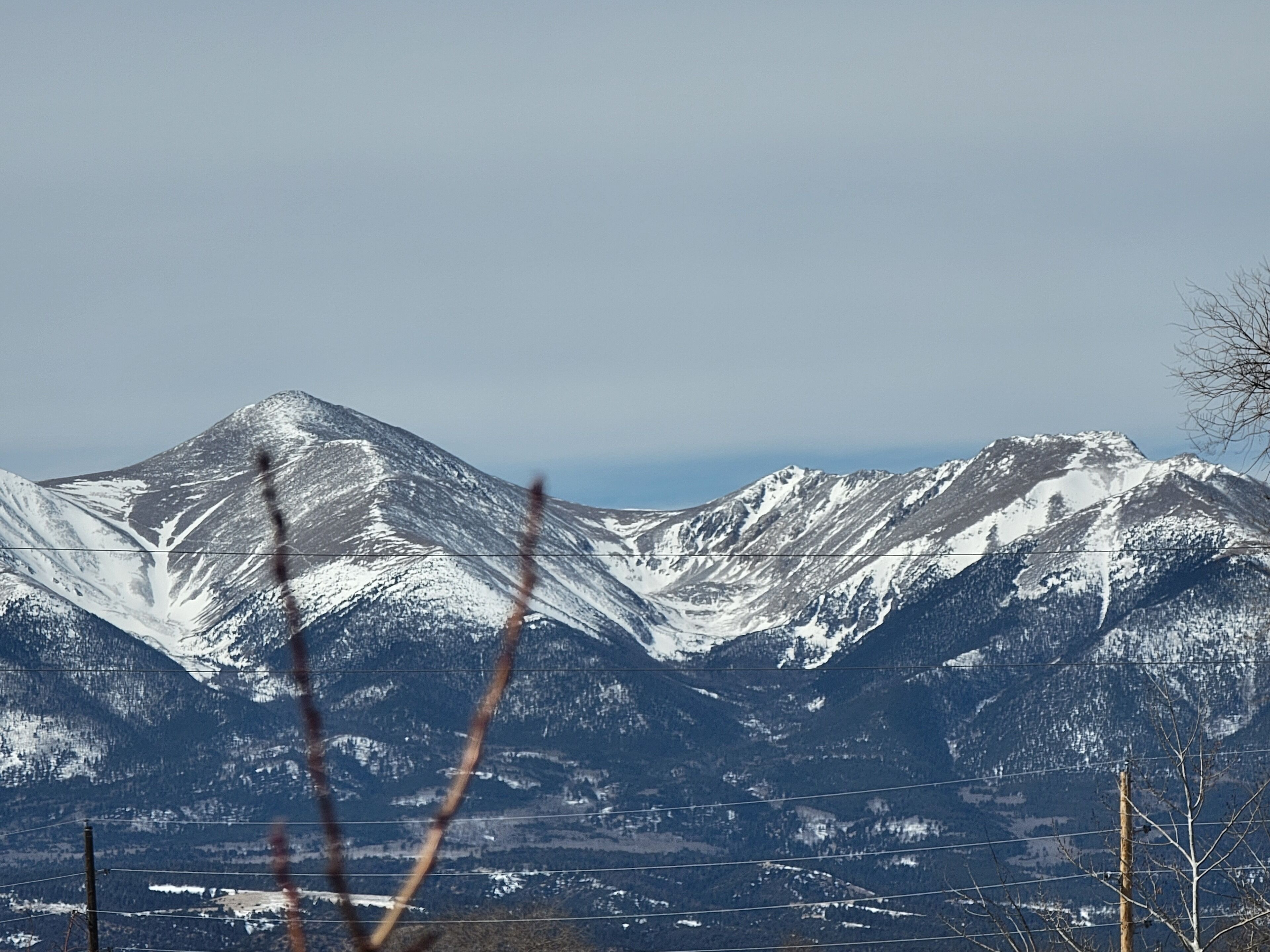 A mountain landscape with snow-covered peaks and a clear sky.