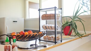 A kitchen counter with a bread display, a fruit bowl, and condiments. - Silver Ridge Lodge (Salida)