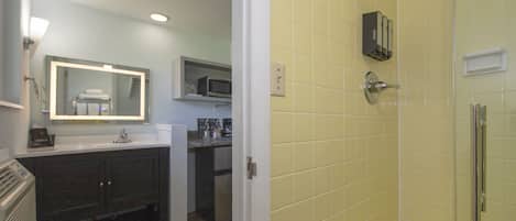 A bathroom with a shower, a sink, and a mirror.