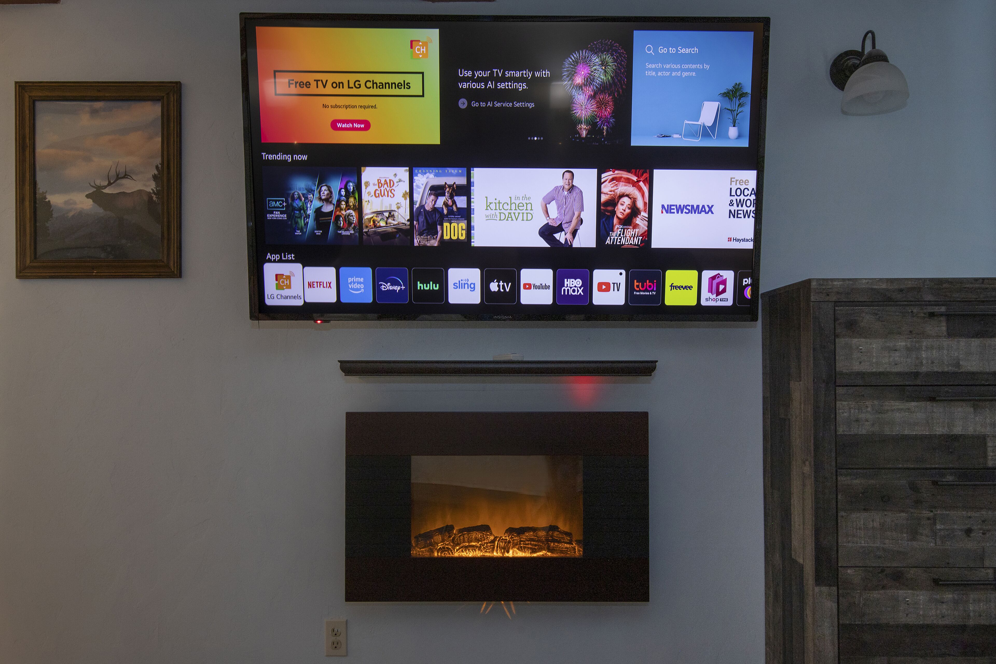 A flat-screen TV mounted on a wall displaying various streaming services and a fireplace below it.