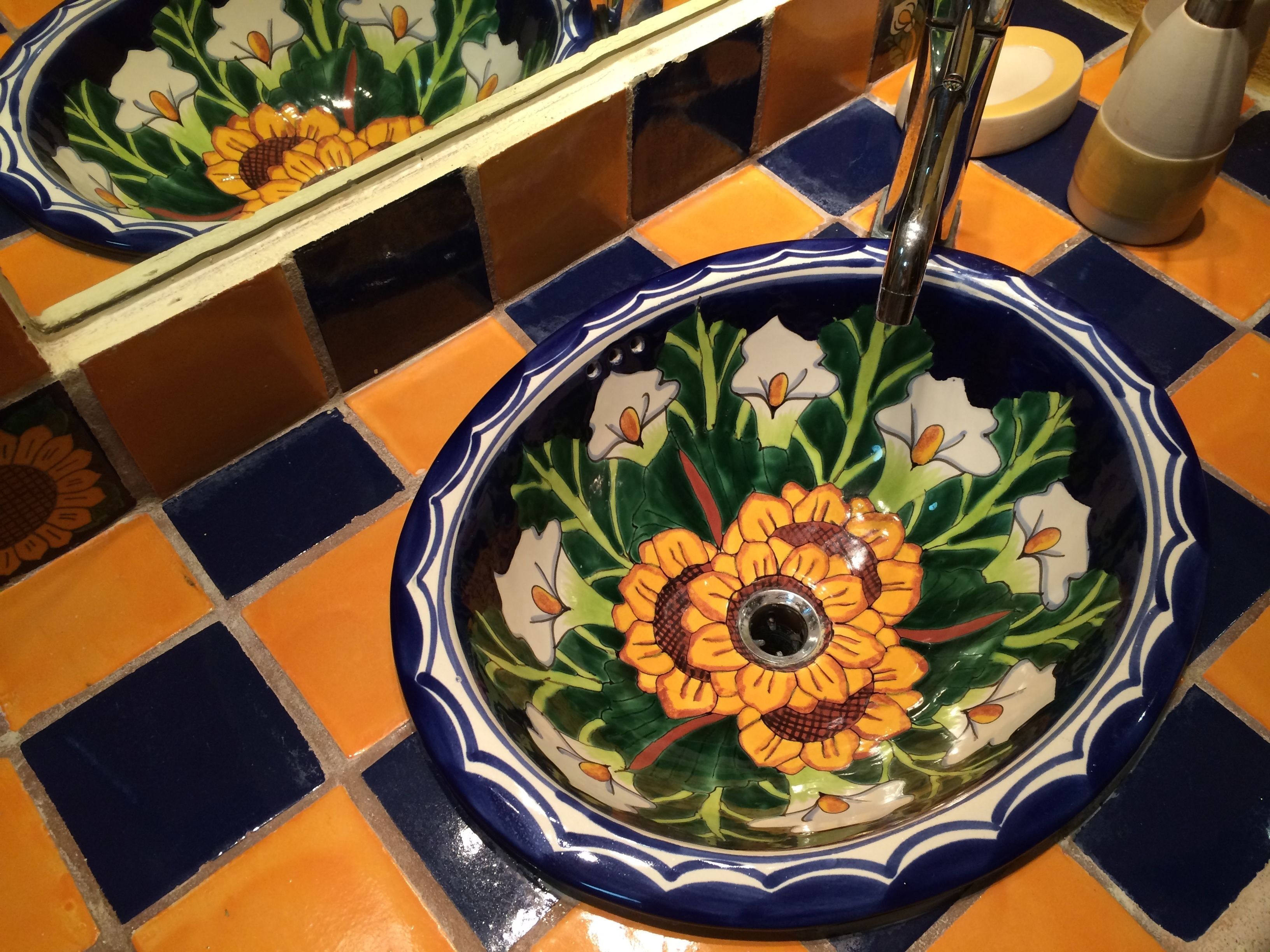 A bathroom with a decorative ceramic sink featuring floral patterns.
