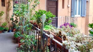 En bygning med balkon, plantekasser og en dør.