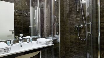 Een moderne badkamer met een douche met glazen wand, een wastafelmeubel en een spiegel.