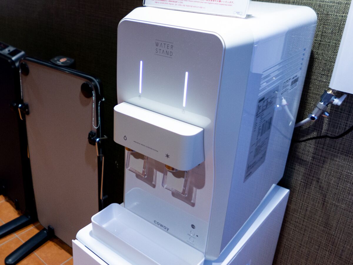 A water dispenser with a control panel, a water stand, and a coway logo.