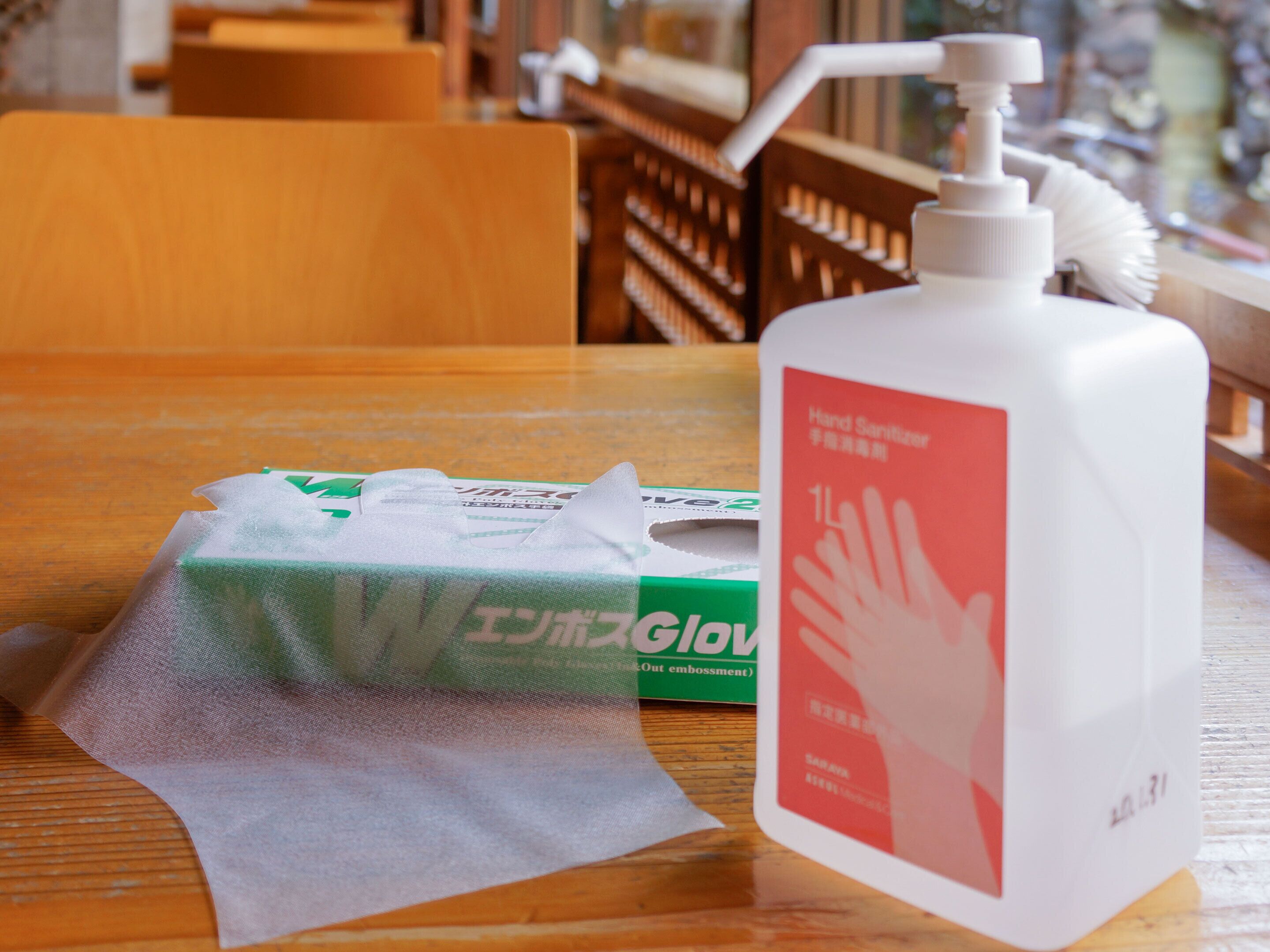 Una mesa con una caja de gel hidroalcohólico y una botella de desinfectante de manos.