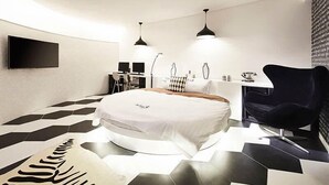 Un dormitorio moderno con una cama redonda, un escritorio y una silla.