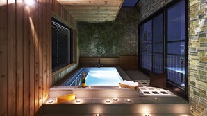 Un área de spa con hidromasaje, velas y una botella de champán.