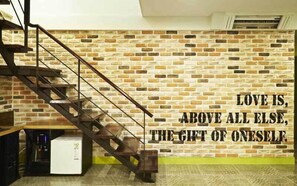 A staircase leading to a room with a brick wall and a motivational quote. - Hotel Boutique 9 (Seoul)