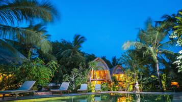 Una piscina al aire libre, sombrillas, sillones reclinables de piscina