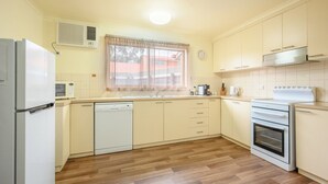 A kitchen with a refrigerator, microwave, dishwasher, oven, and cabinets.