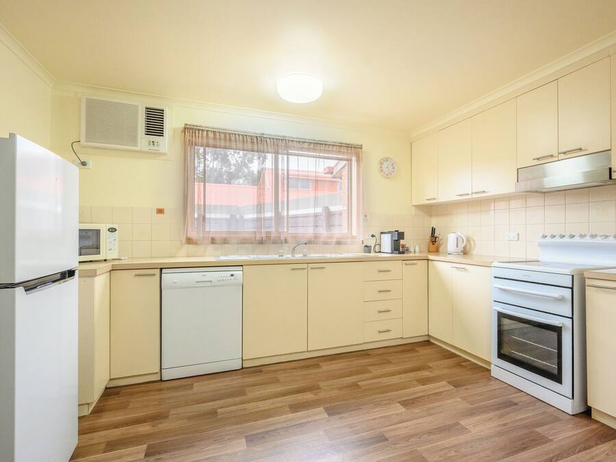 A kitchen with a refrigerator, microwave, dishwasher, oven, and cabinets.