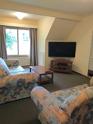 Apartamento, 3 habitaciones | Zona de estar | Smart TV de 40 pulgadas con canales digitales, una televisión