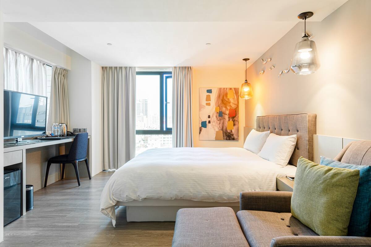 Une chambre d’hôtel moderne dotée d’un grand lit, d  ’un bureau et d’un coin salon confortable.