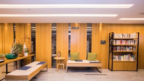 Une bibliothèque moderne avec des panneaux de bois, un banc, une petite table avec des plantes et une étagère.