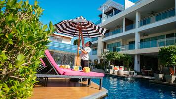Relax by the pool surrounded by lush greenery and take in the views of the hotel's upper floors.