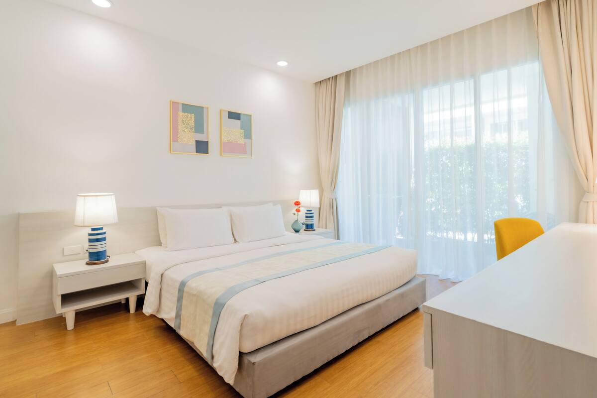 Een hotelkamer met een bed, nachtkastjes, een bureau en een stoel.