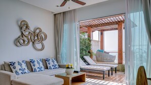 A modern living room with a sofa, coffee table, and a decorative wall piece. - The Pelican Residence & Suite Krabi (Krabi)