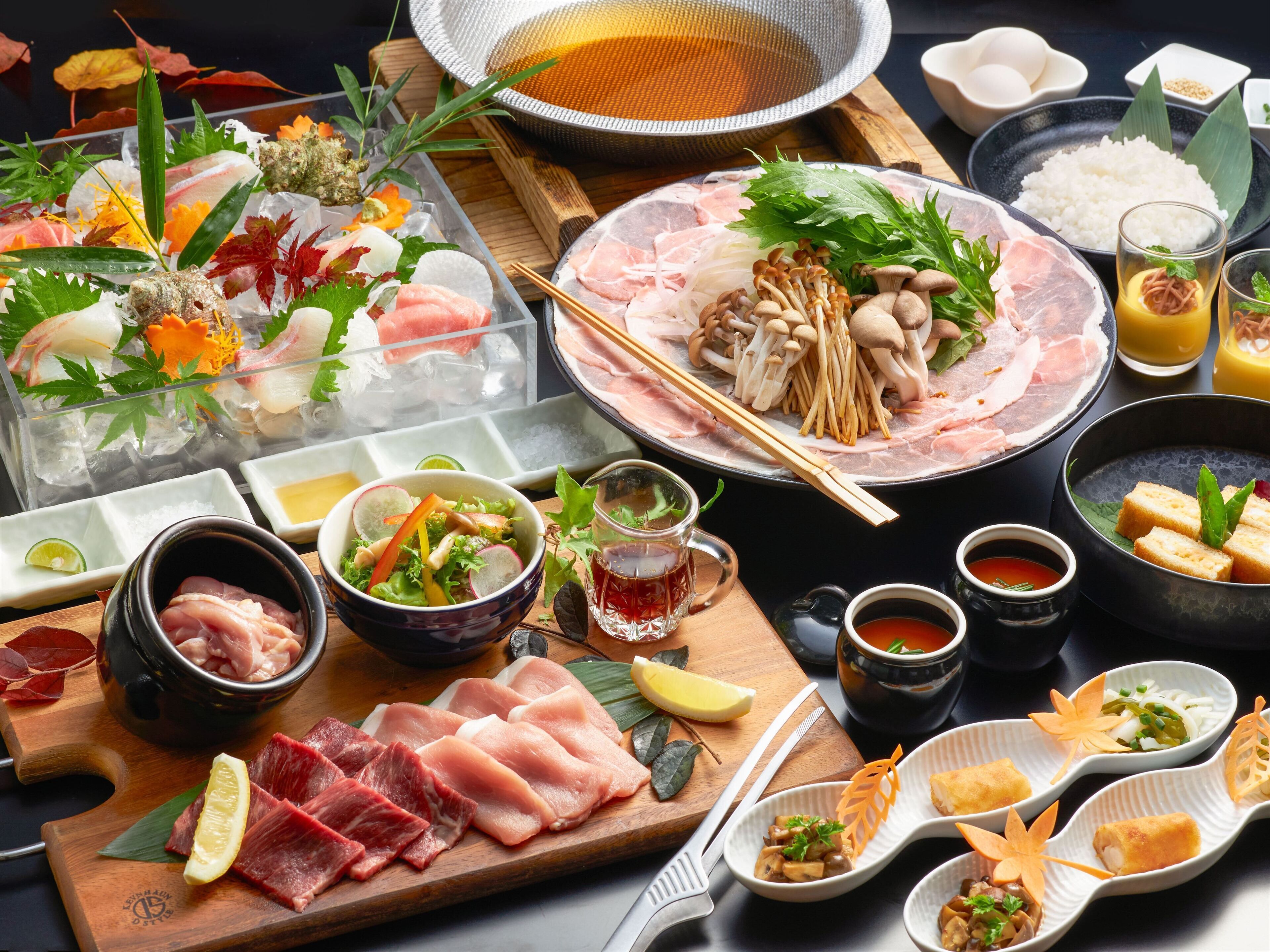 A variety of food items including sushi, sashimi, and a bowl of soup.