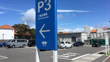 A blue parking sign with an arrow pointing left, indicating the direction for hotel guests.