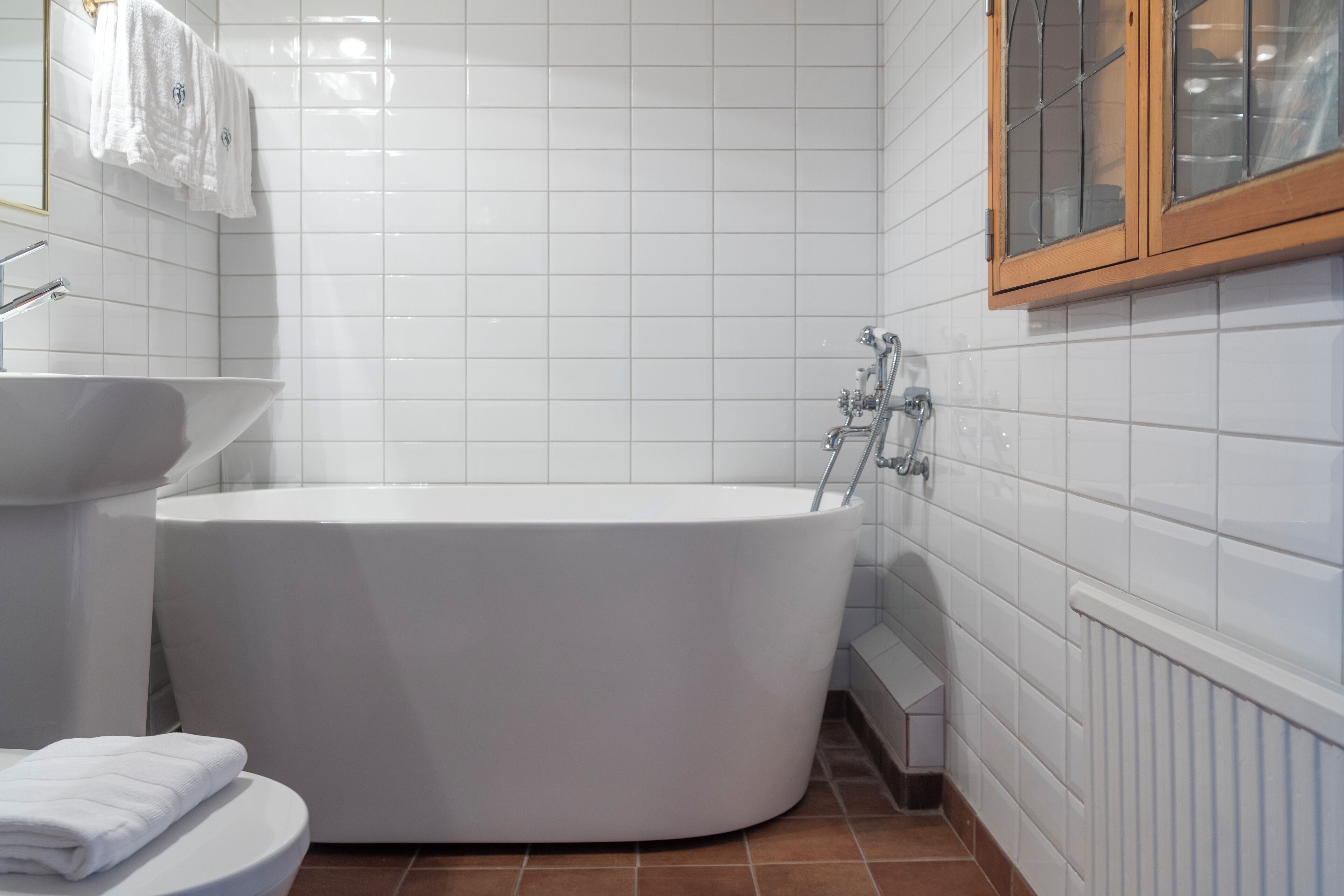 Een moderne badkamer met een vrijstaand bad, een witte wastafel en een toilet.