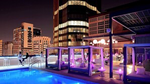 A rooftop pool area with seating and a bar, surrounded by modern buildings. - Courtyard by Marriott World Trade Center Abu Dhabi (Abu Dhabi)