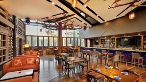 A spacious restaurant with high ceilings, wooden floors, and a mix of seating including tables and sofas. - Courtyard by Marriott World Trade Center Abu Dhabi (Abu Dhabi)