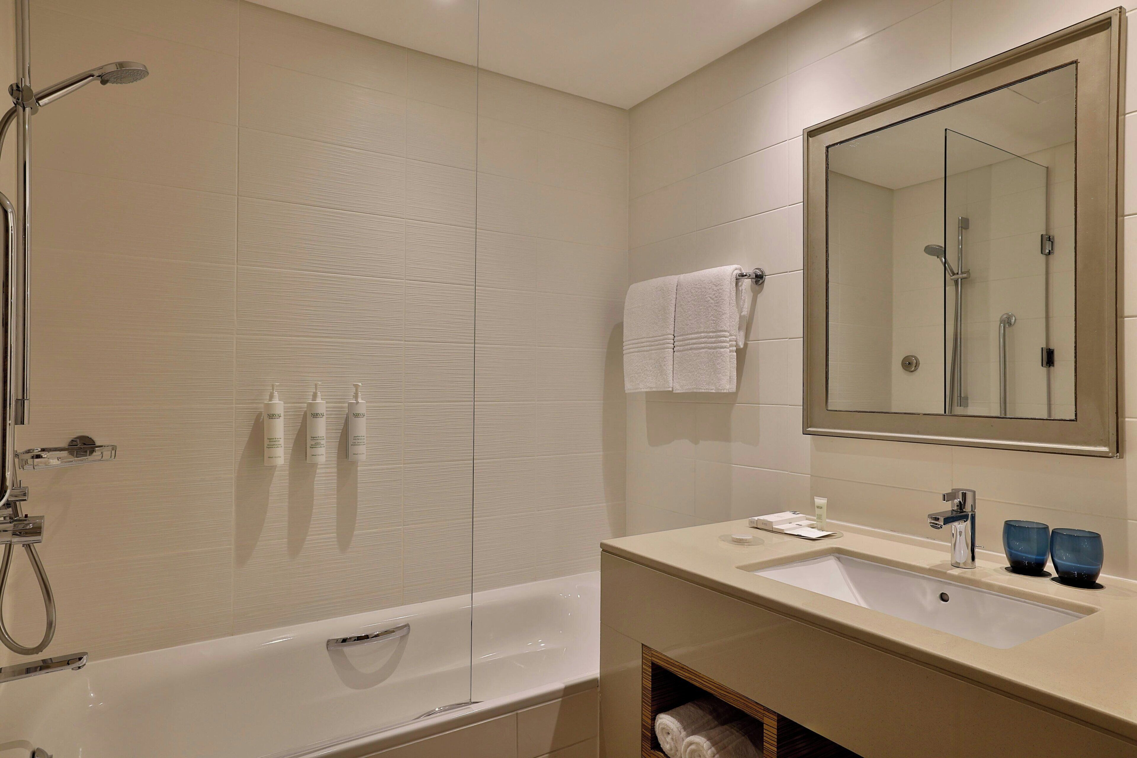 Un baño moderno con bañera, lavamanos y ducha.
