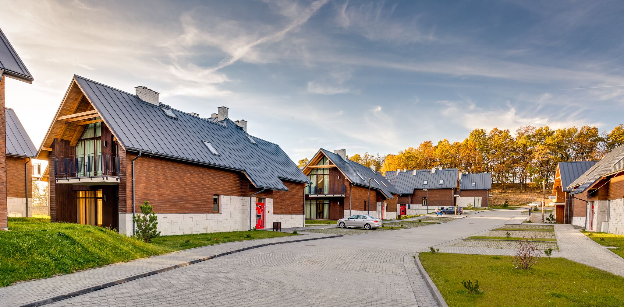 A modern residential area with houses featuring sloped roofs and wooden exteriors.