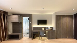Ein modernes Hotelzimmer mit Schreibtisch, Stuhl und einem an der Wand befestigten Flachbildfernseher.