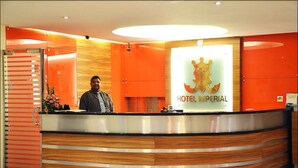 Ein modern gestalteter Hotelrezeptionsschalter mit gut sichtbarem Logo und einer Theke für Gäste.