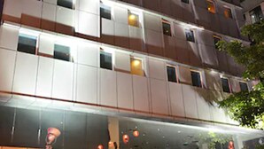 Ein mehrstöckiges Hotel mit beleuchteter Beschilderung und einem gut sichtbaren Eingang.