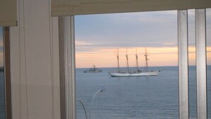 A view of the sea from a window with a metal railing and a ship in the distance. - Apart Hotel Punta Azul (Punta del Este)