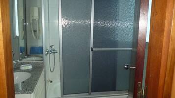 Une salle de bain avec une douche, un lavabo et un miroir.