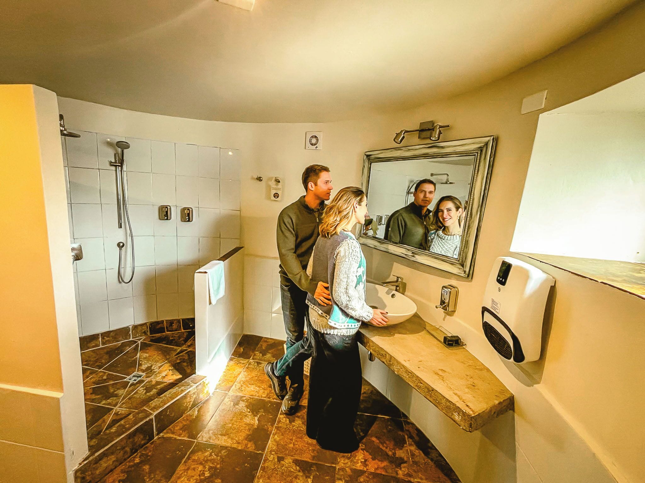 Une salle de bain avec une douche, un lavabo et un miroir.