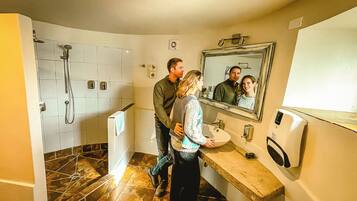 Une salle de bain avec une douche, un lavabo et un miroir.