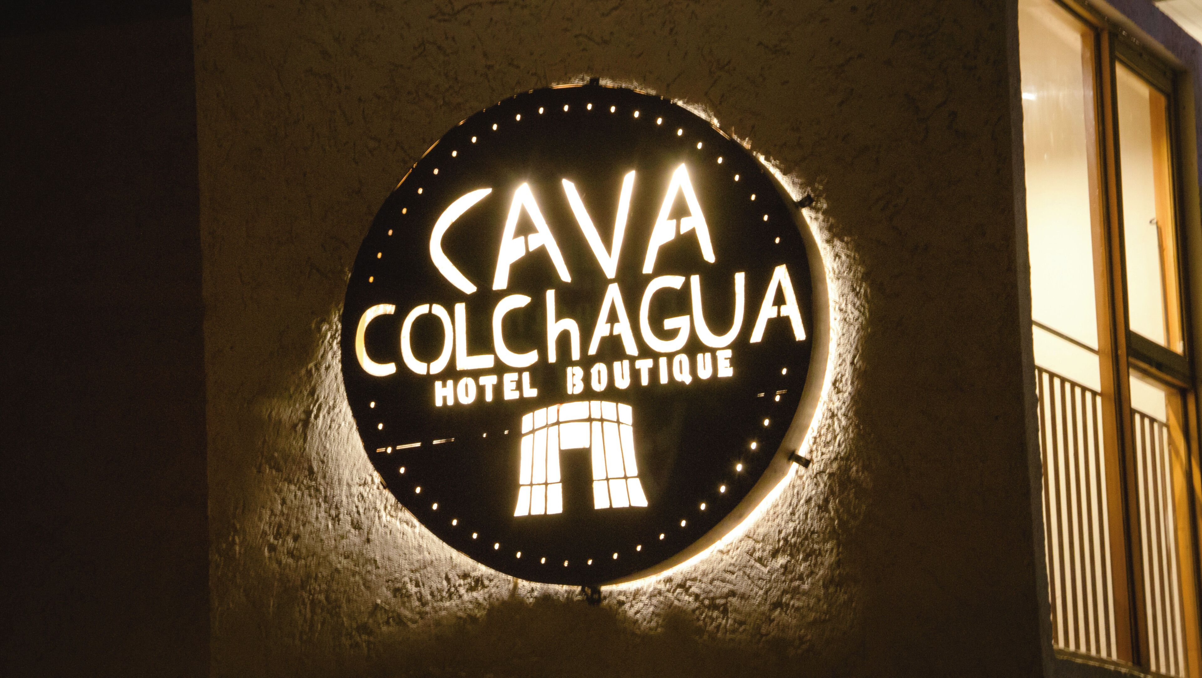 A circular sign with the text "CAVA COLCHAGUA HOTEL BOUTIQUE" and a building silhouette.