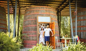 Una estructura de madera rústica con una puerta, rodeada de follaje.