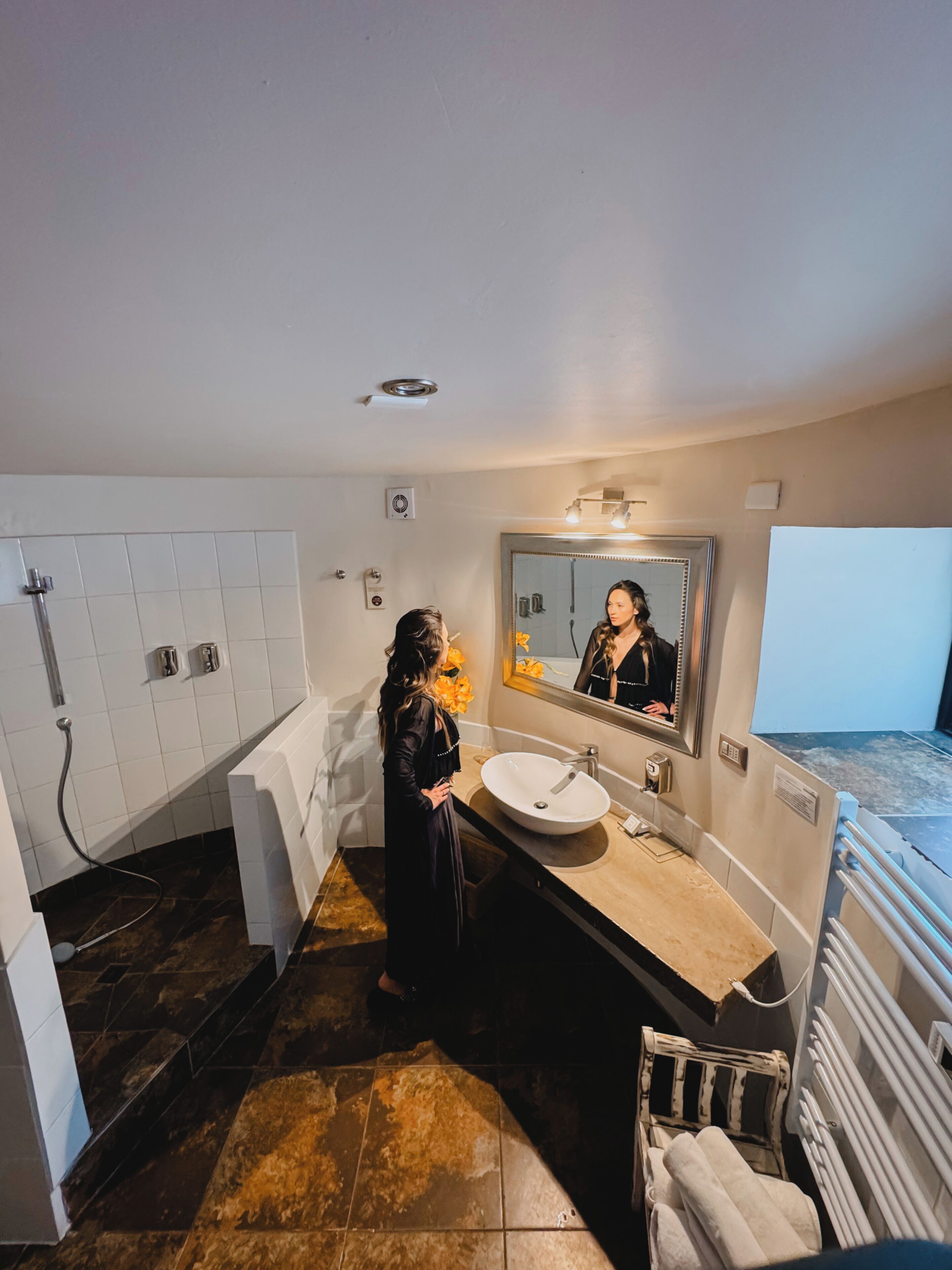 Ein modernes Badezimmer mit einem großen Spiegel, einem Waschbecken und einer Badewanne.