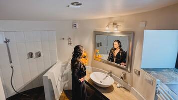 Ein modernes Badezimmer mit einem großen Spiegel, einem Waschbecken und einer Badewanne.