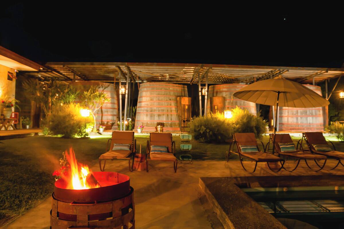 An outdoor patio area with a fire pit, lounge chairs, and a pool.