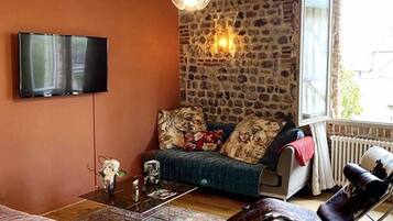 Deluxe suite, uitzicht op tuin | Woonkamer | Een 81-cm flatscreentelevisie met digitale zenders en televisie