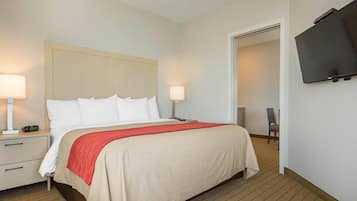 A hotel room with a bed, bedside tables, a TV, and a chair.