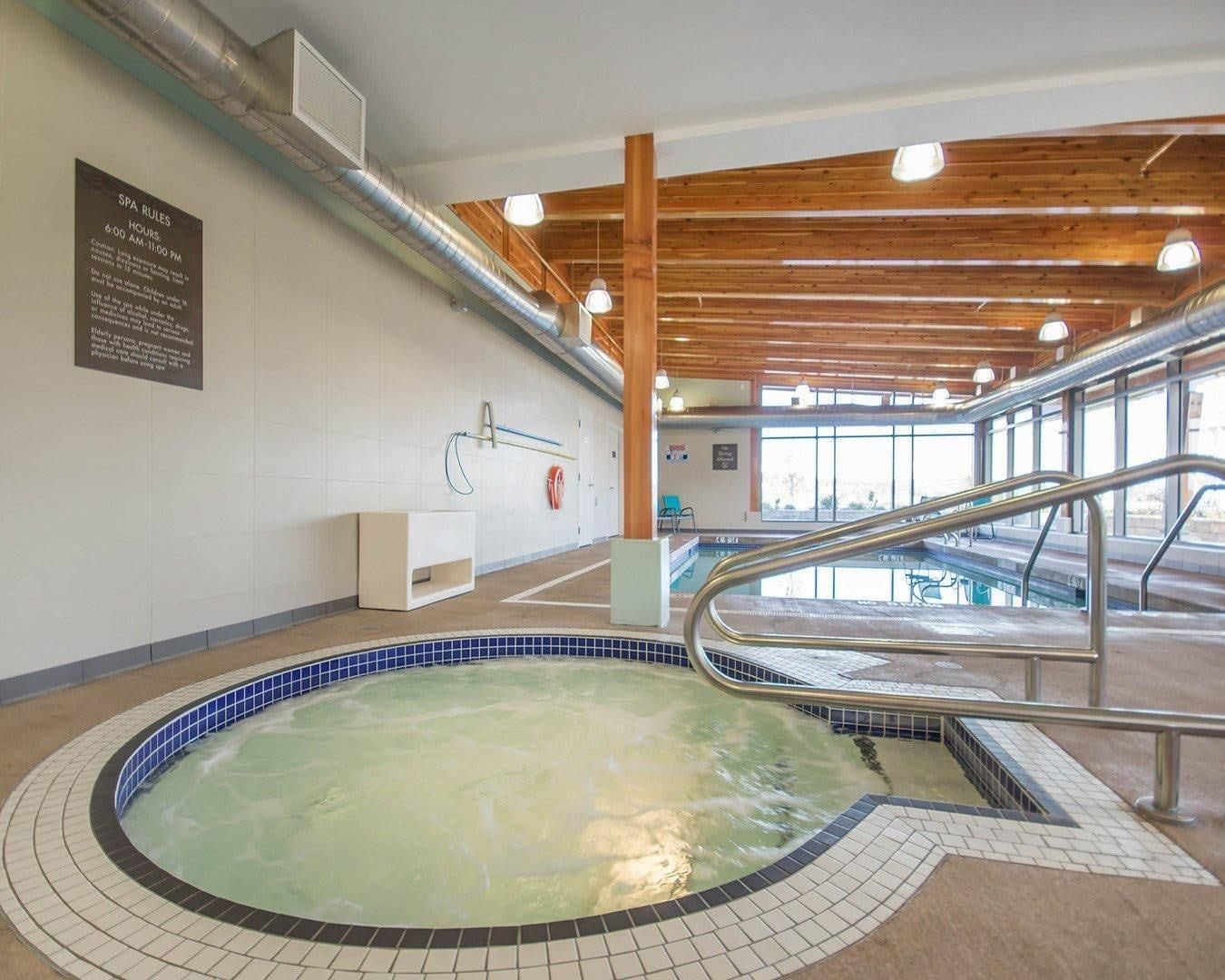 Et wellnessområde med jacuzzi, træbjælker i loftet og et skilt med spa-regler.