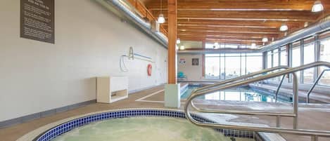 A spa area with a hot tub, wooden ceiling beams, and a sign with spa rules.